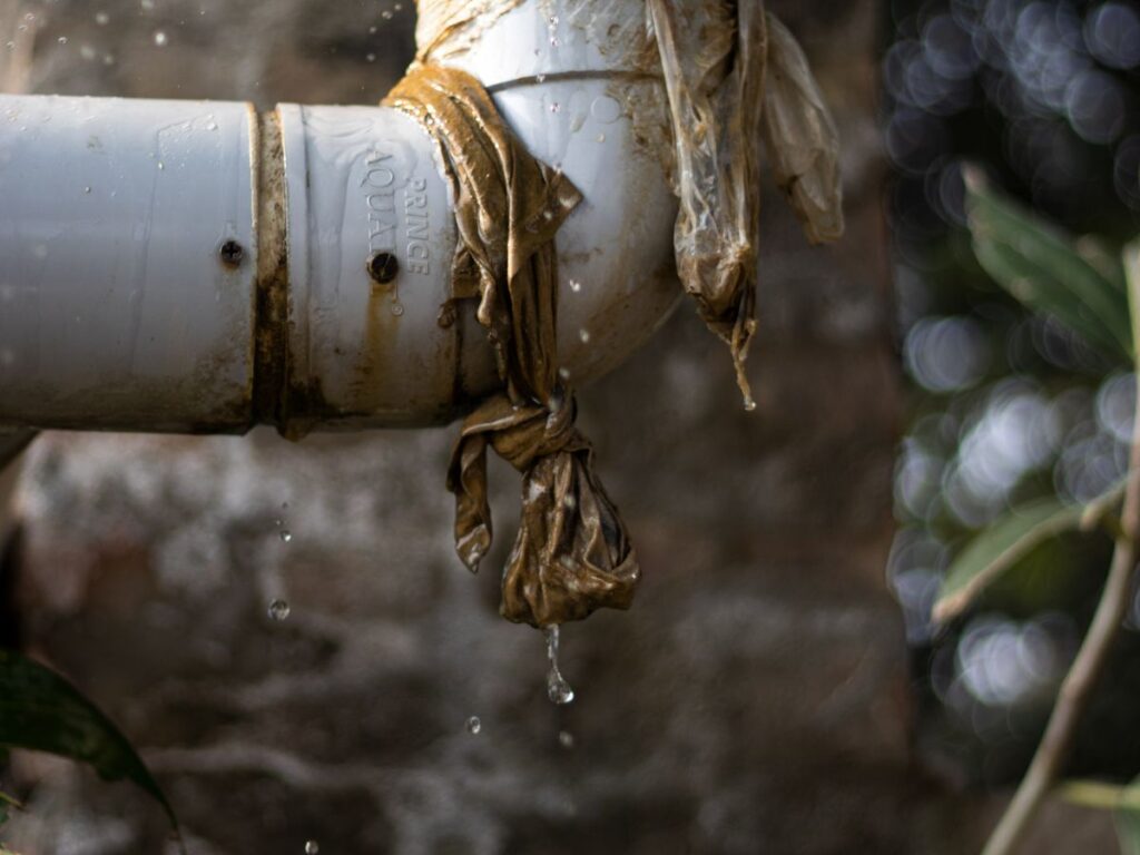 Close-up of a leaking water pipe joint with drips of water